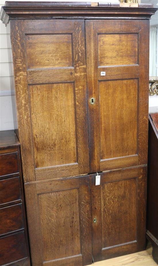 An early 19th century oak cupboard enclosed by two pairs of panelled doors, (some damage) H.185cm